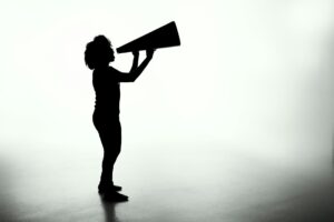 silhouetted women holding large megaphone