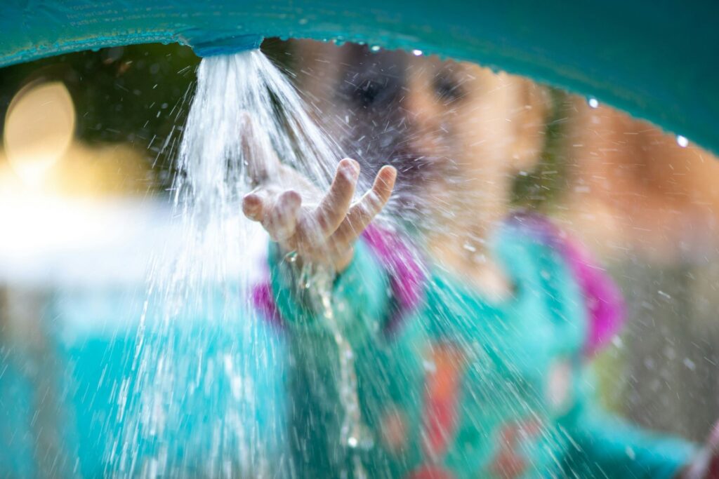 child touching water spout